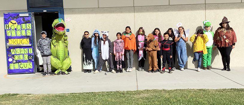 Teachers and student standing in front of the Home of the Eagles mural